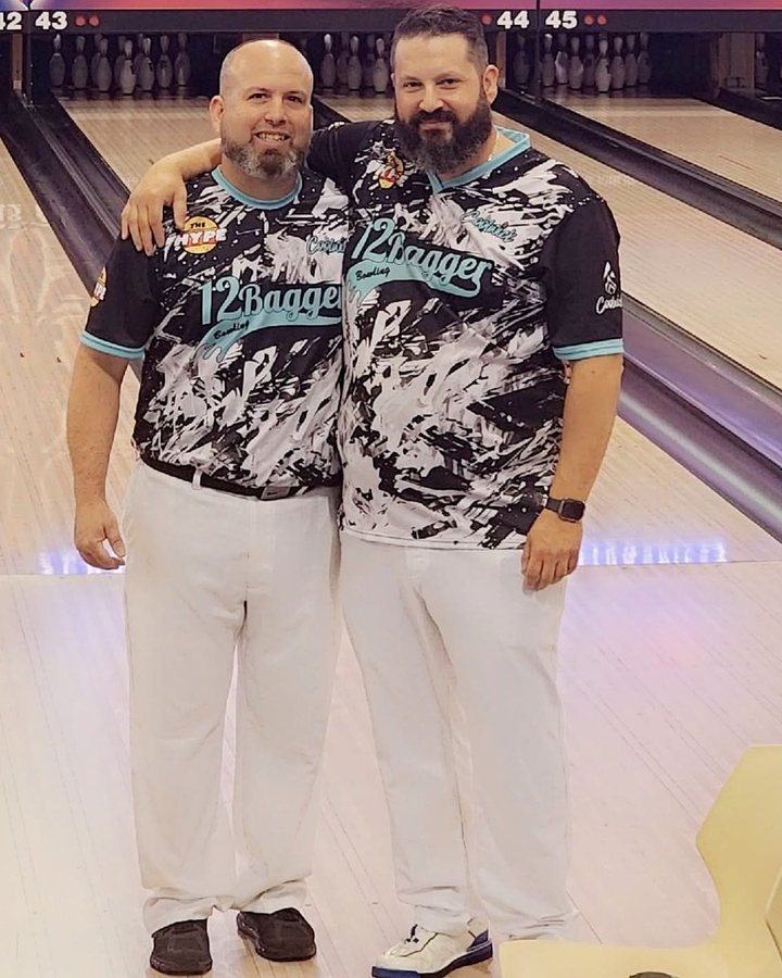 Two bowlers in matching black and teal 12Bagger jerseys at the Open Championships